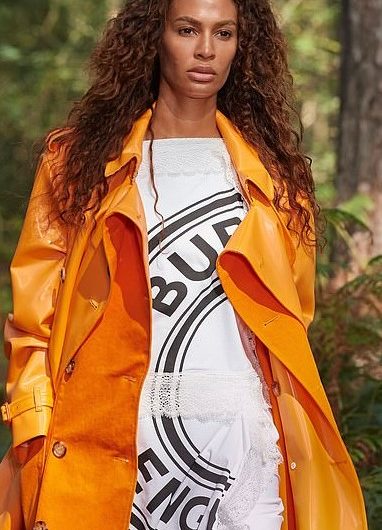 At the Virtual London Fashion Week show, Joan Smalls showed off her model figure in a bright orange burberry trench coat